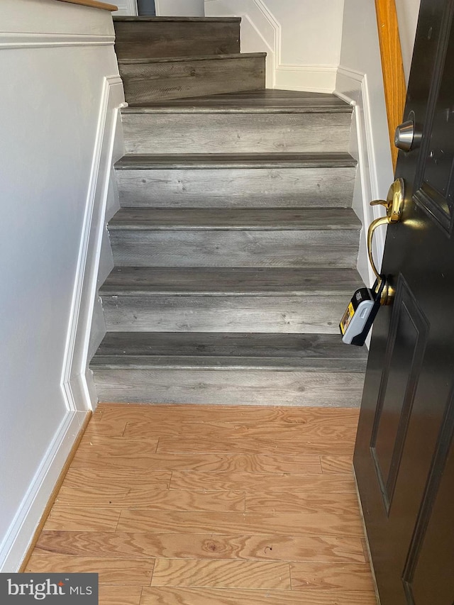 staircase with hardwood / wood-style floors