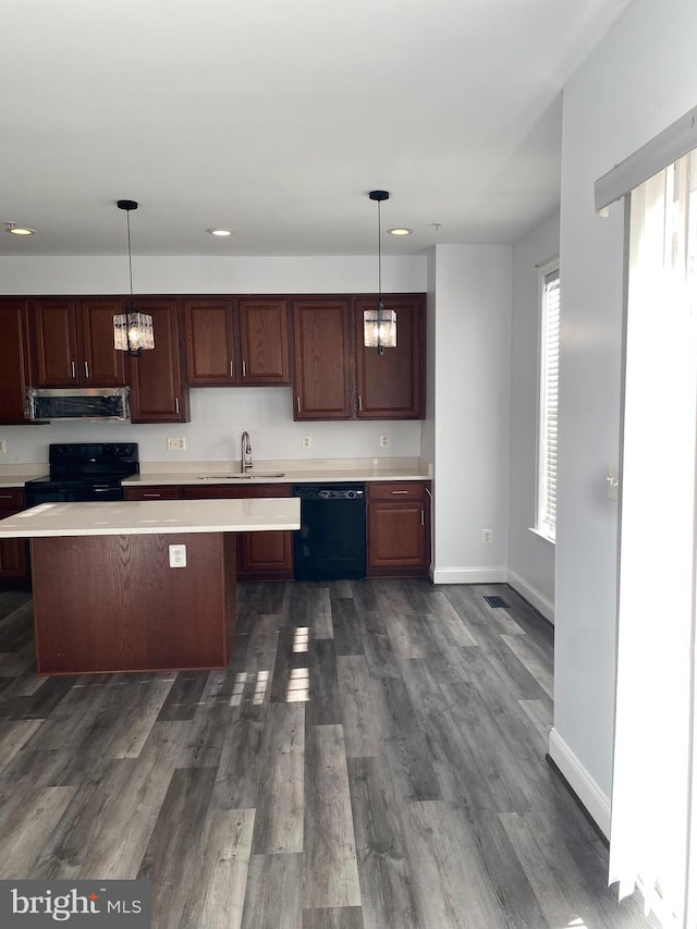 kitchen featuring black appliances, sink, hanging light fixtures, and extractor fan