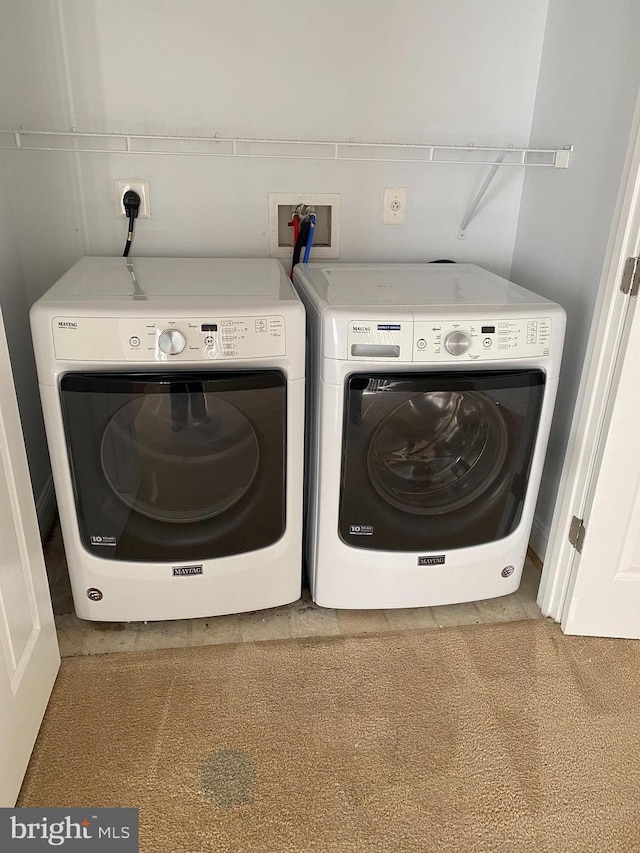 laundry room featuring light carpet and washer and clothes dryer