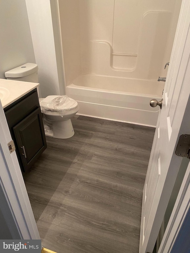 full bathroom with shower / bathing tub combination, hardwood / wood-style floors, vanity, and toilet