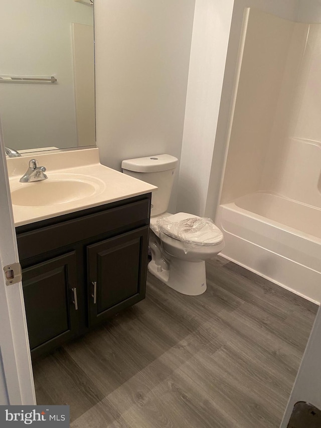 full bathroom featuring hardwood / wood-style floors, vanity, toilet, and shower / bathing tub combination