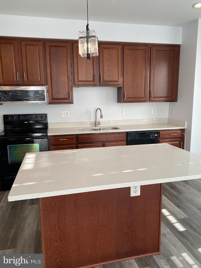 kitchen featuring exhaust hood, black appliances, sink, decorative light fixtures, and a kitchen island