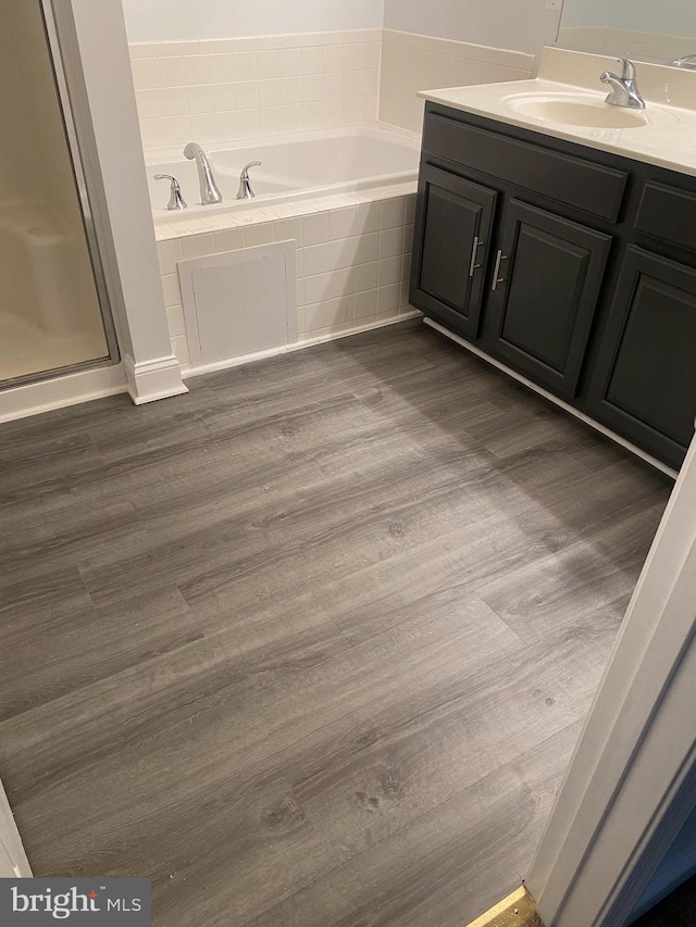 bathroom featuring hardwood / wood-style floors, vanity, and shower with separate bathtub