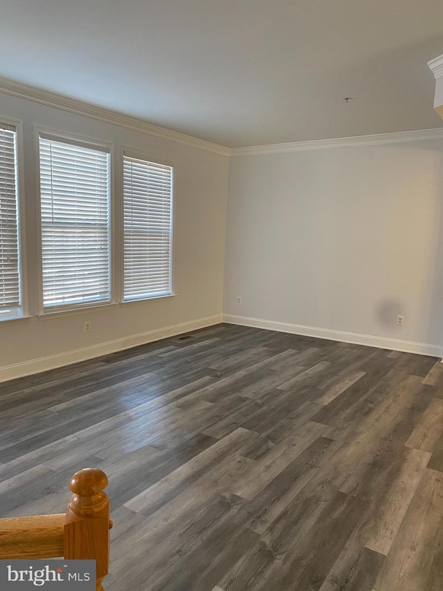 empty room with dark hardwood / wood-style flooring and ornamental molding