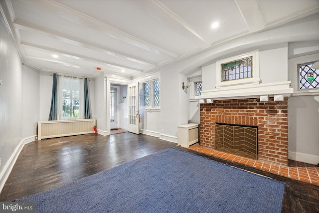 unfurnished living room with beam ceiling, radiator heating unit, dark hardwood / wood-style flooring, crown molding, and a fireplace