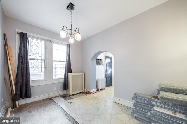 foyer entrance featuring radiator heating unit and an inviting chandelier