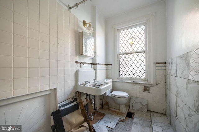 bathroom featuring toilet and tile walls