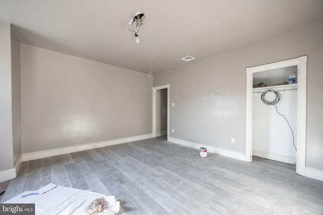 unfurnished bedroom featuring hardwood / wood-style floors and a closet