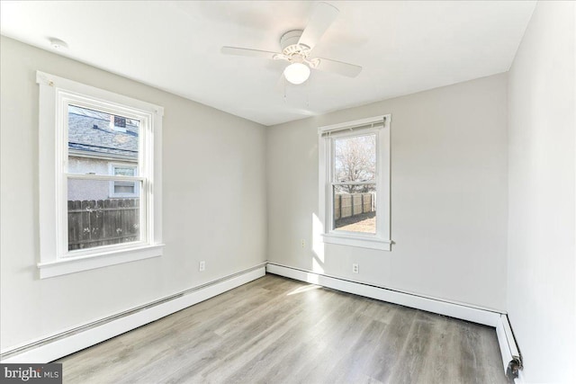 spare room featuring ceiling fan, light hardwood / wood-style flooring, and a baseboard radiator