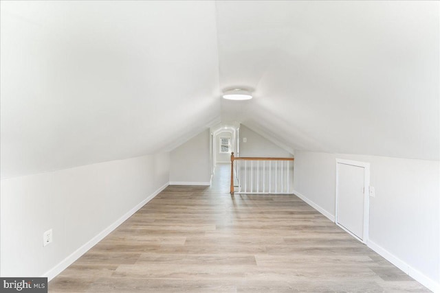 bonus room featuring light wood-type flooring and vaulted ceiling