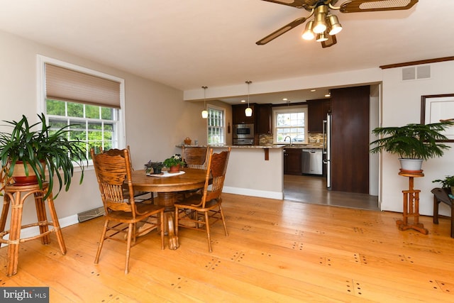 dining room with ceiling fan, light hardwood / wood-style floors, and sink