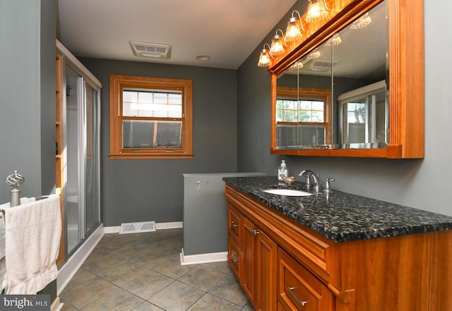 bathroom featuring tile patterned flooring, vanity, and an enclosed shower