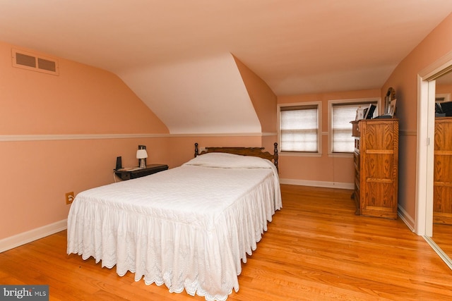 bedroom with lofted ceiling and light hardwood / wood-style flooring