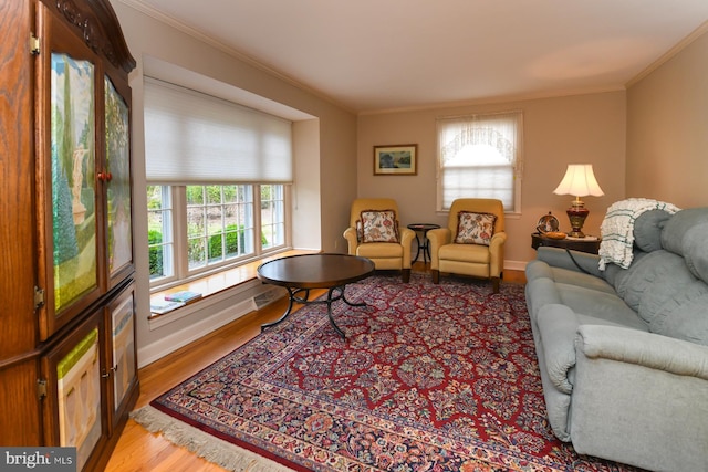 living room featuring hardwood / wood-style floors, a healthy amount of sunlight, and crown molding