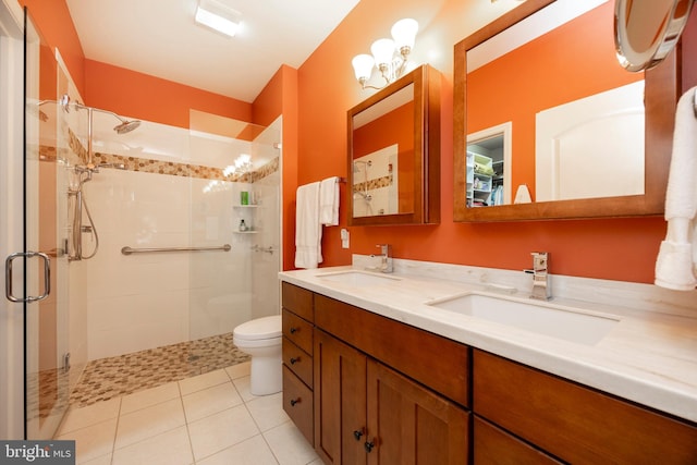 bathroom featuring a shower with door, vanity, tile patterned flooring, and toilet