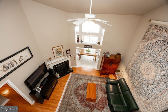 living room featuring ceiling fan, hardwood / wood-style floors, and a high ceiling