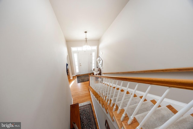 stairs with a towering ceiling and hardwood / wood-style floors