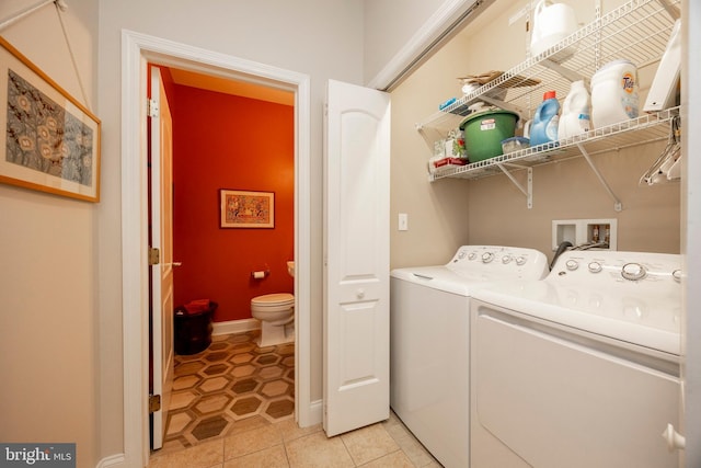 clothes washing area featuring washer and dryer and light tile patterned floors