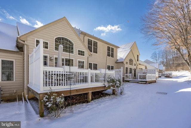 snow covered rear of property featuring a wooden deck