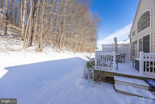 yard covered in snow featuring a deck