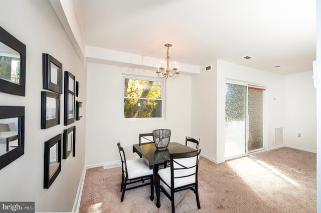 dining room with a notable chandelier and light colored carpet