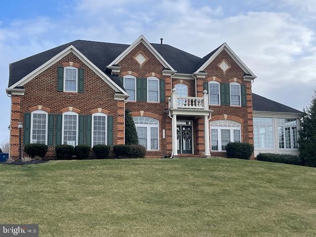 view of front of house featuring a front yard and a balcony