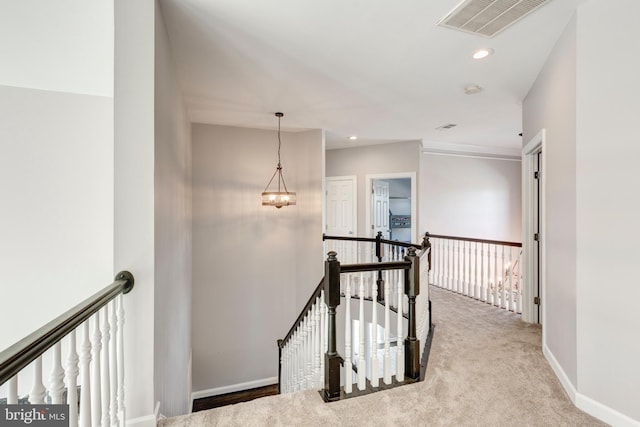 hall featuring a notable chandelier and light colored carpet