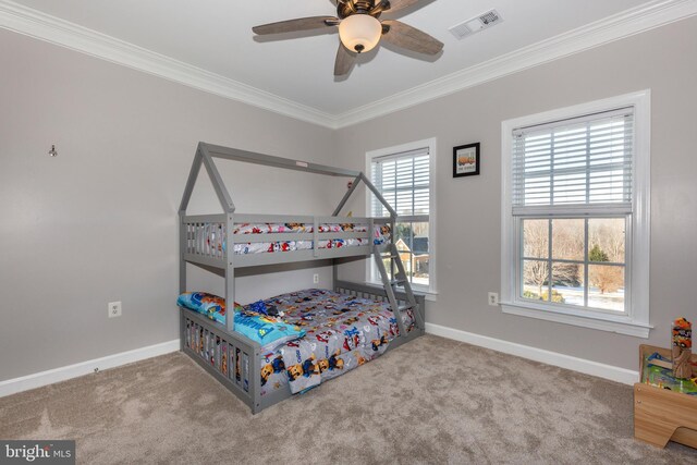 carpeted bedroom featuring ceiling fan and crown molding