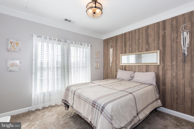 bedroom with ornamental molding, wooden walls, and carpet