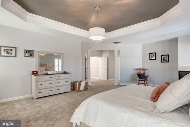 bedroom with a tray ceiling, a multi sided fireplace, light carpet, and ornate columns