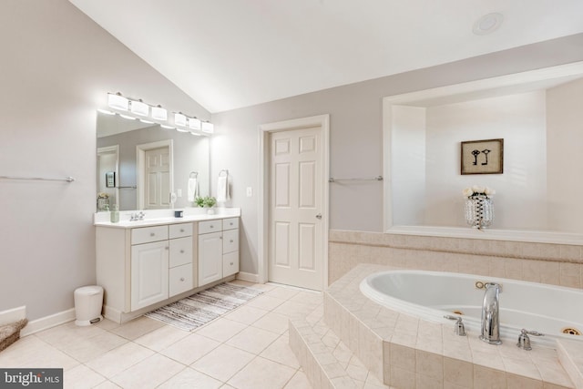 bathroom featuring tiled bath, tile patterned flooring, vaulted ceiling, and vanity