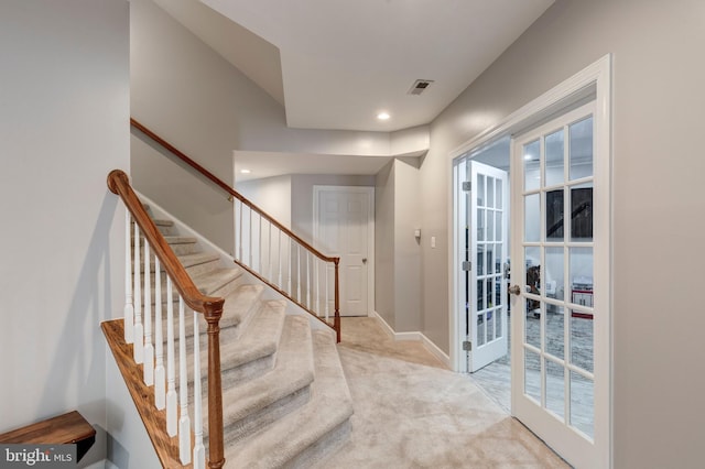 stairs featuring french doors and carpet flooring