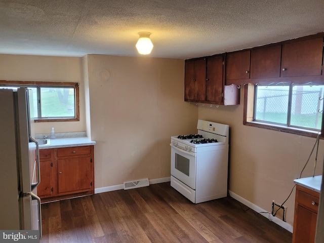 11 Green St, Frostburg, MD 21532 - kitchen with a textured ceiling, white appliances, a wealth of natural light, and dark wood-type flooring