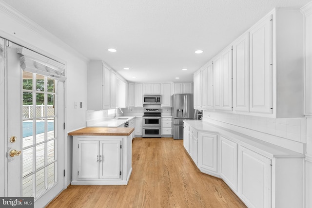 kitchen featuring backsplash, sink, white cabinetry, and stainless steel appliances