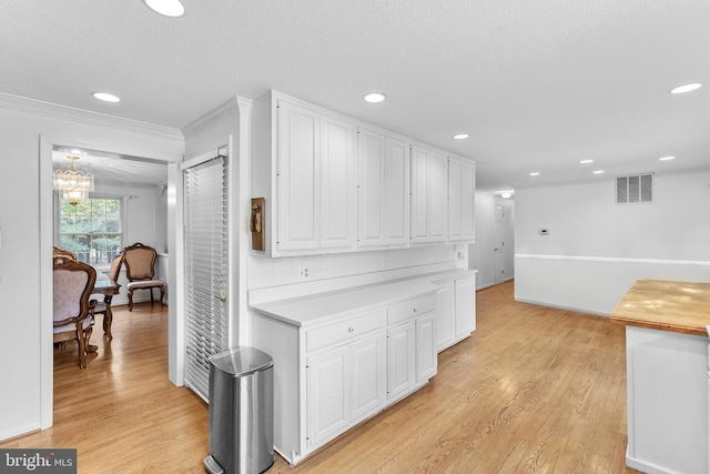 kitchen featuring a chandelier, light hardwood / wood-style flooring, white cabinetry, and tasteful backsplash