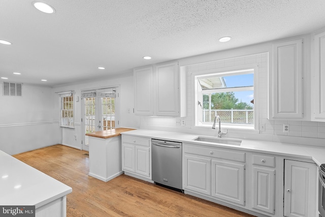 kitchen with white cabinetry, dishwasher, sink, backsplash, and plenty of natural light