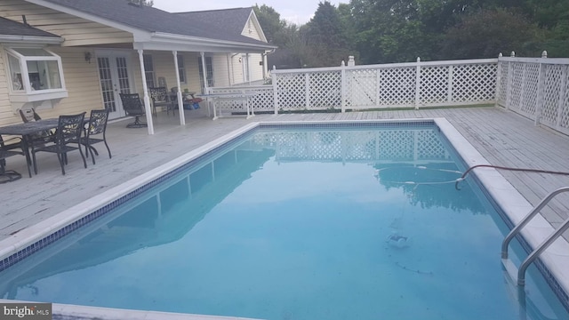 view of pool featuring a wooden deck and french doors