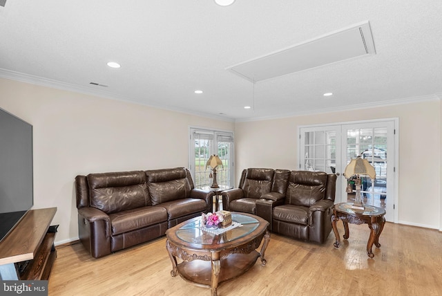 living room featuring light hardwood / wood-style floors, a wealth of natural light, and crown molding