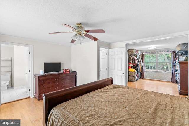 bedroom featuring ensuite bath, ceiling fan, a closet, and light wood-type flooring