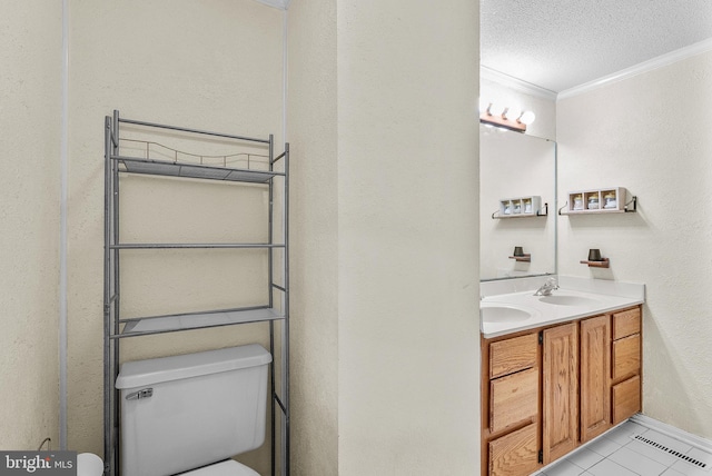 bathroom featuring tile patterned floors, ornamental molding, vanity, a textured ceiling, and toilet