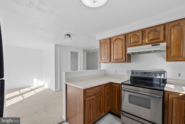 kitchen featuring electric range, kitchen peninsula, and light carpet