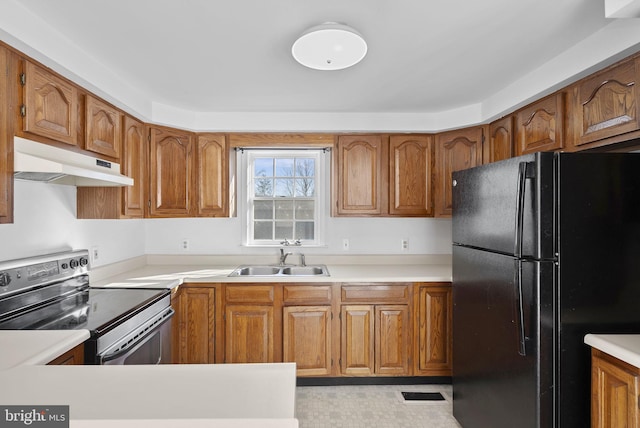 kitchen featuring black refrigerator, stainless steel electric range, and sink