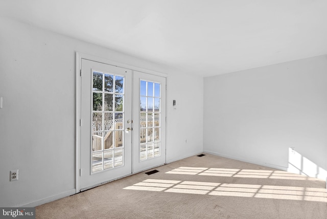 unfurnished room with light carpet and french doors