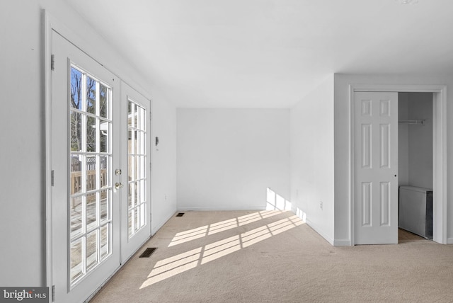 spare room with light carpet and french doors