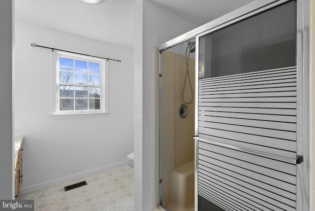 bathroom with vanity, a shower with shower door, and toilet