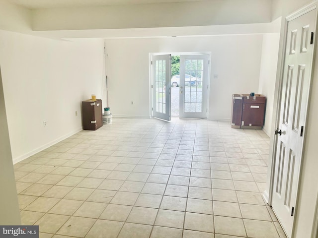 empty room with french doors and light tile patterned flooring