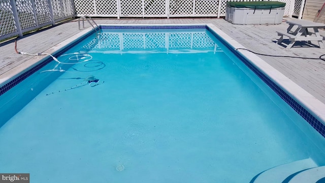 view of swimming pool with a hot tub and a deck