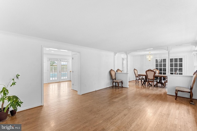 living area featuring hardwood / wood-style floors, french doors, and ornamental molding