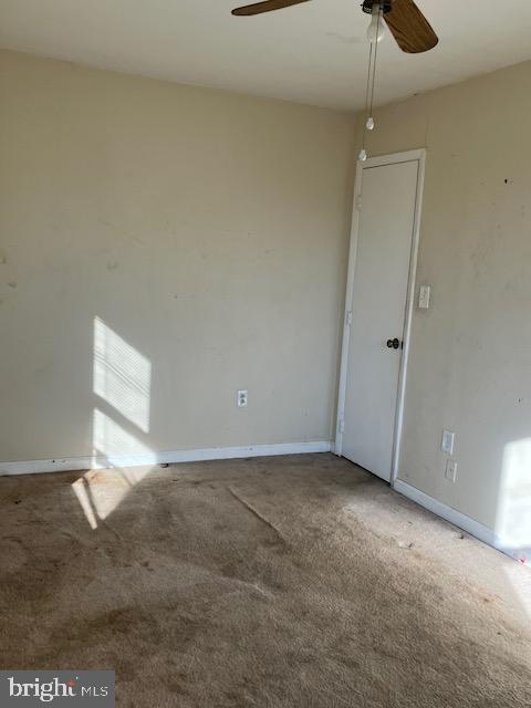 carpeted empty room featuring ceiling fan