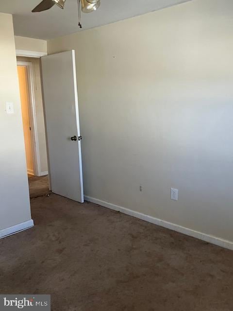 unfurnished room featuring dark carpet and ceiling fan